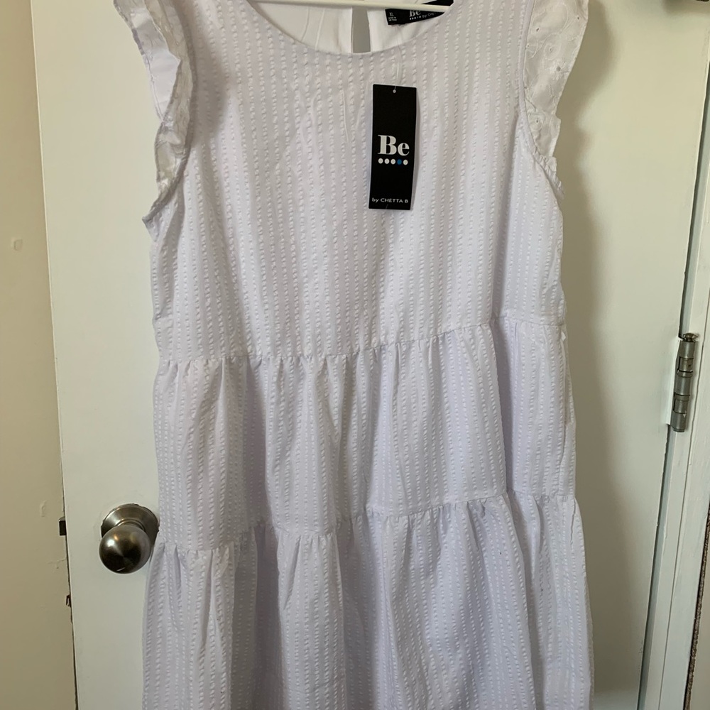 White tiered dress, short sleeves, baby doll type dress, below knee.